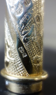 Small engraved mark on a mace handle surrounded by engraved decoration.