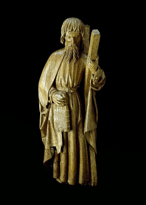 mage shows a wooden statue of St Andrew, he is carrying his cross under his left arm