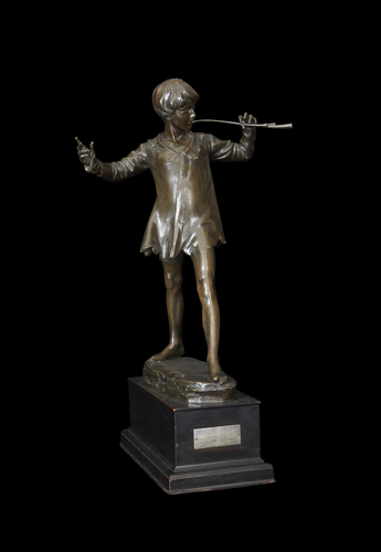 A bronze statue of a boy with a flute.