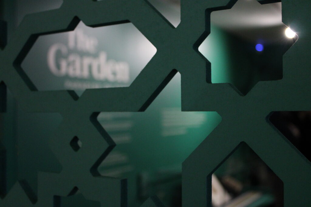The wall title 'The Garden' seen through a patterned grid.